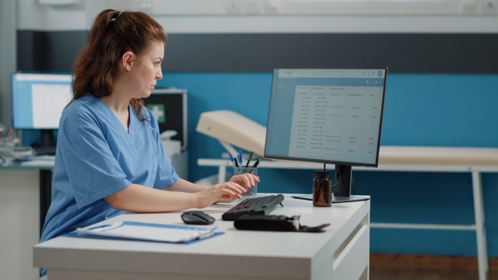 Clinic staff member updating the practice listing on a computer